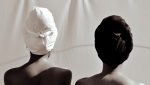 Vue artistique de dos de deux femmes avec des têtes couvertes sur fond blanc.jpg