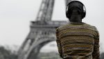 Back view of an African-American man in headphones with Eiffel tower on the background